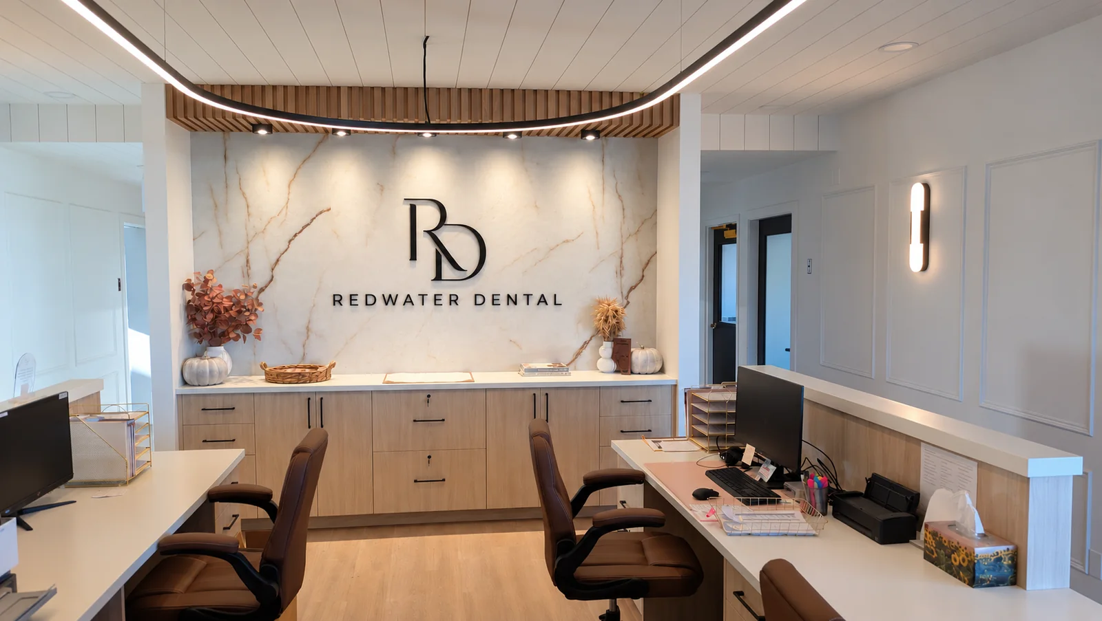 Renovated reception with the Redwater Dental logo and curved ceiling lighting